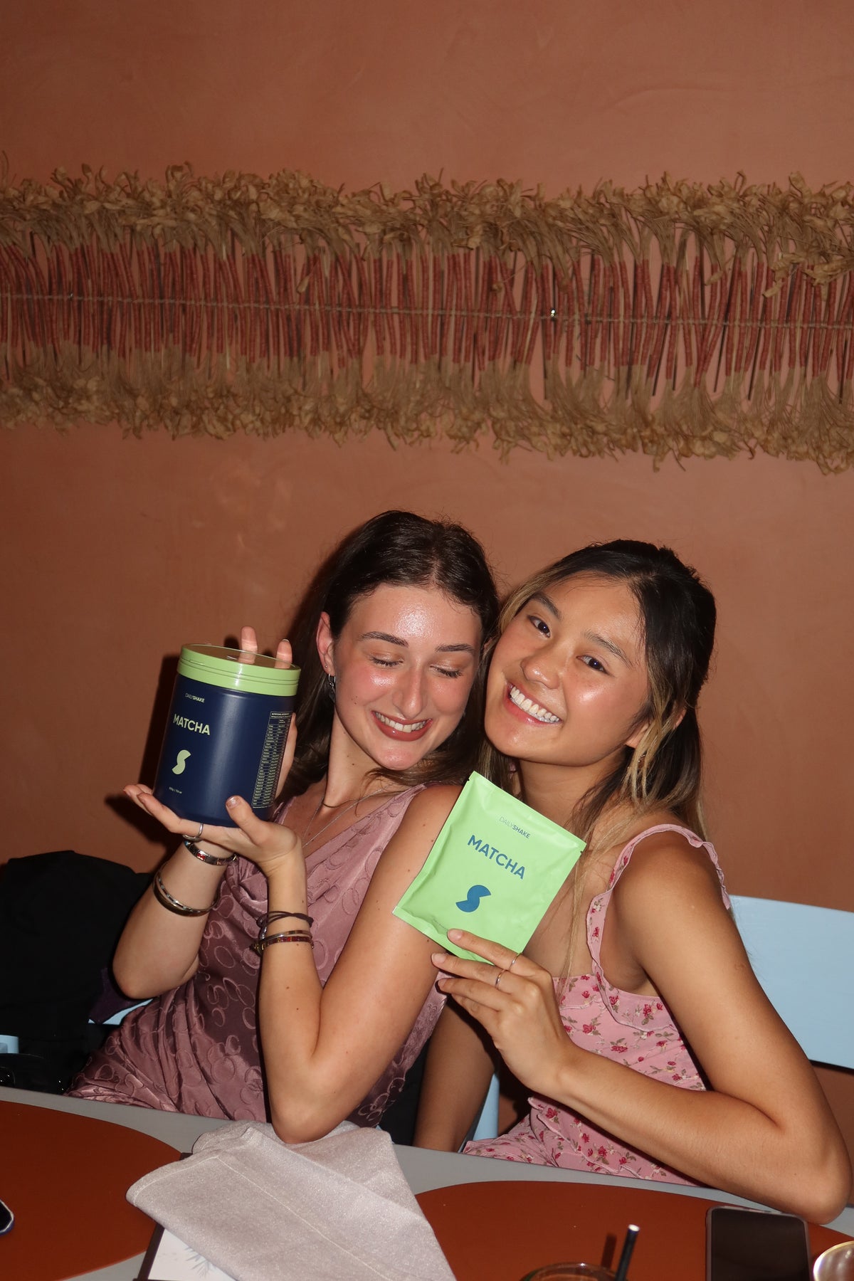 Australian protein powder community event in Sydney with women holding a Matcha protein powder jar and sachet