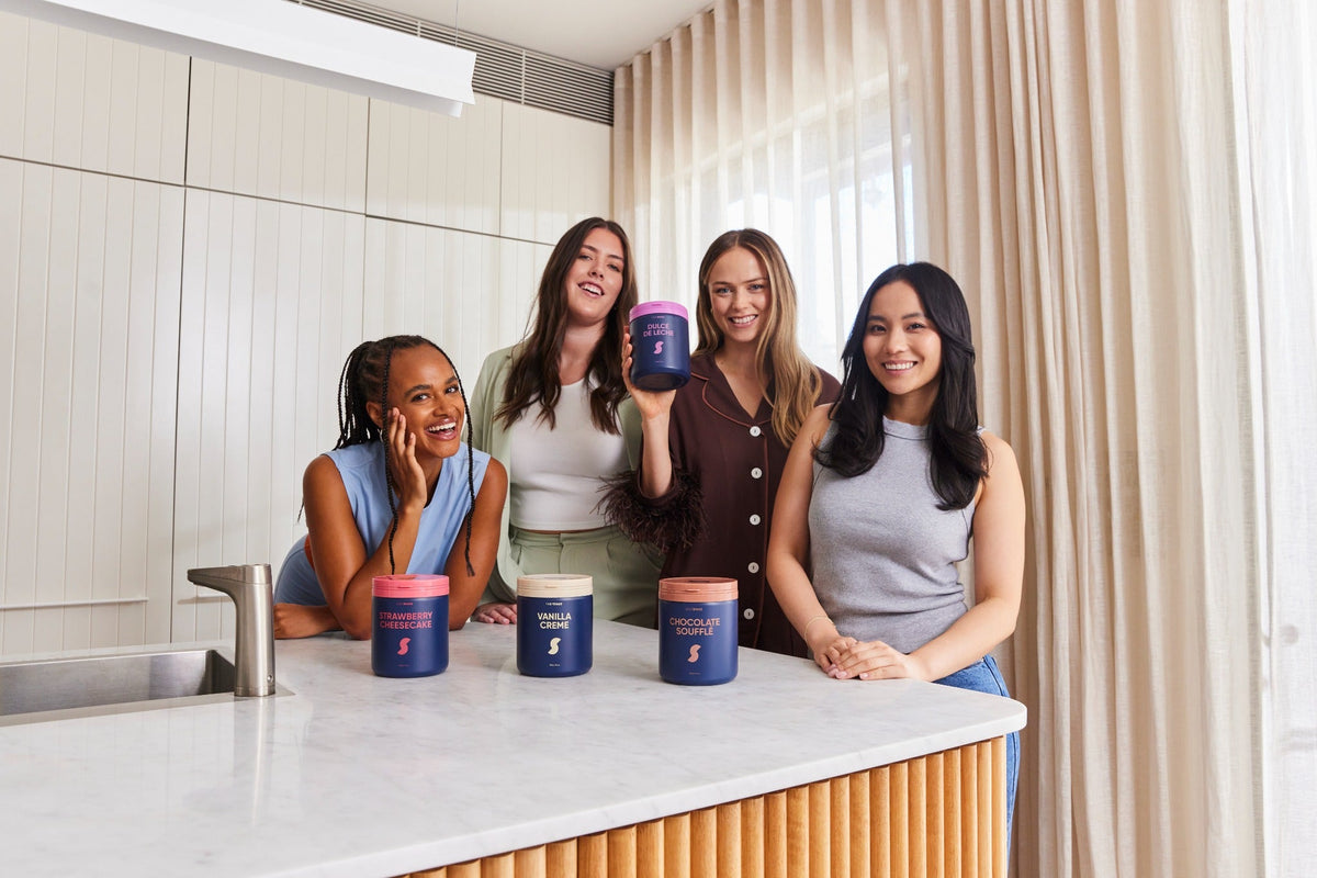 Australian women with a selection of Daily Shake protein powder jars
